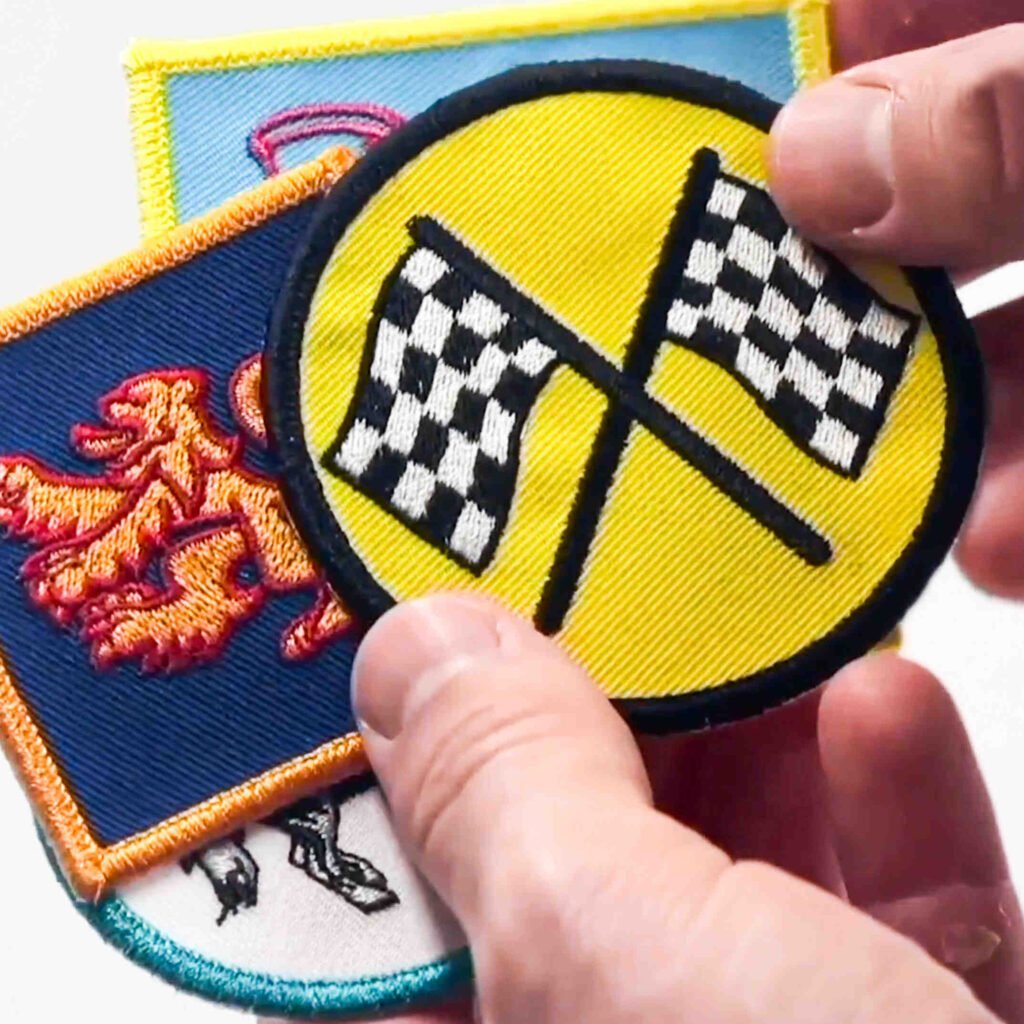 Hand holding various embroidery patches